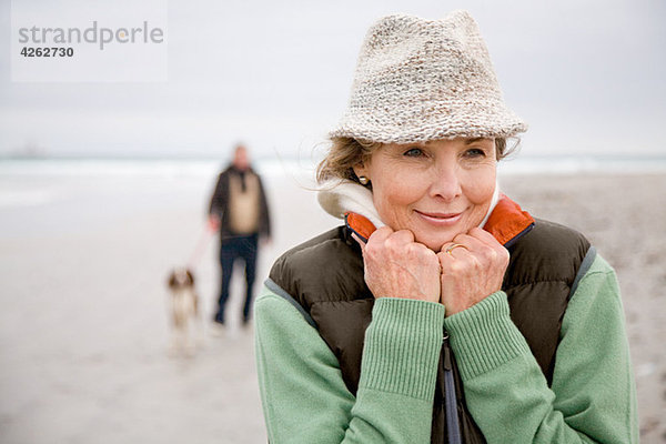 Frau am Strand  Mann und Hund im Hintergrund