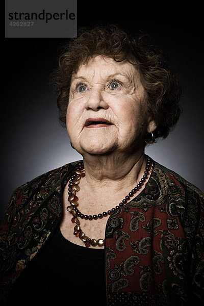 Studio-Porträt einer älteren Frau  die nach oben schaut