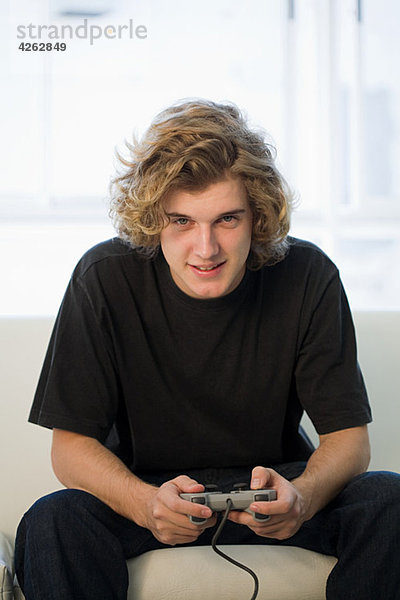 Teenager-Junge spielt auf der Spielkonsole