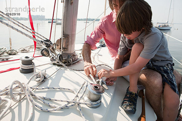 Vater und Sohn an Bord der Yacht mit Seil