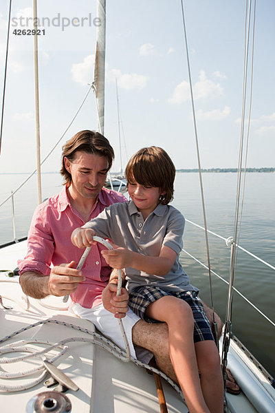 Vater und Sohn an Bord der Yacht mit Seil