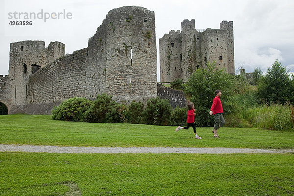 Vater und Tochter laufen auf Trim Castle  County Meath  Irland