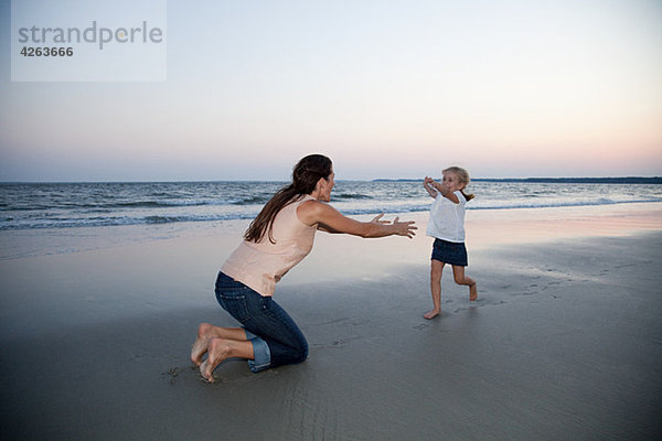 Mädchen rennt zur Mutter am Strand