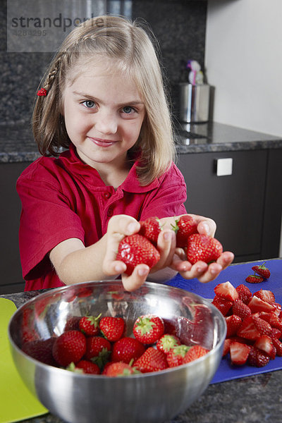 Mädchen beim Zubereiten von Erdbeeren