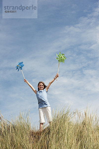 Girl Holding Windmühlen am Himmel