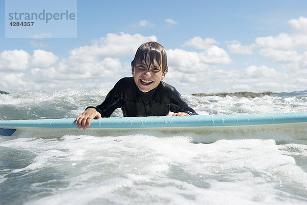 Kleiner Junge auf dem Surfbrett im Meer