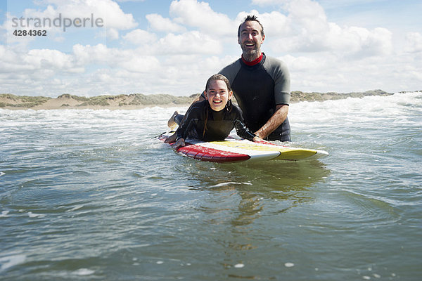 Vater und Tochter surfen im Meer