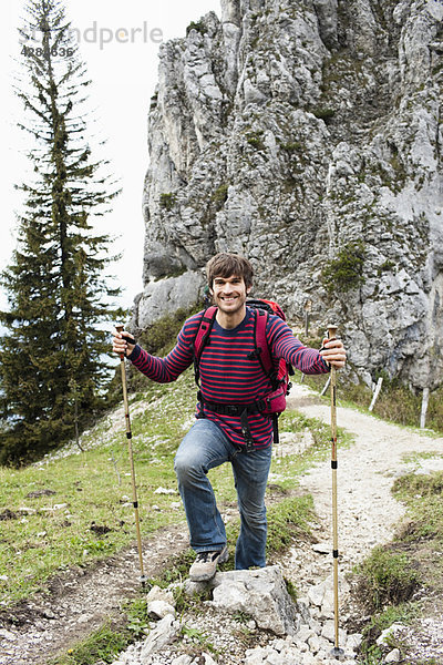 Mann mit Wanderstöcken auf dem Bergweg