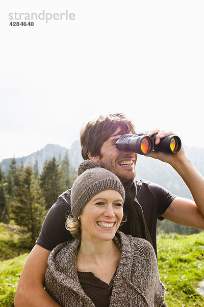 Paar mit Fernglas zur Beobachtung der Landschaft