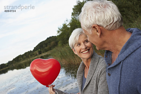 Seniorenpaar mit rotem Herzen