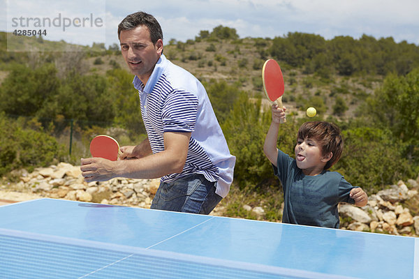 Vater und Sohn spielen Tischtennis