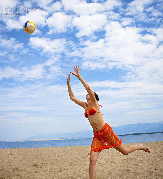 Frau beim Volleyball am Strand