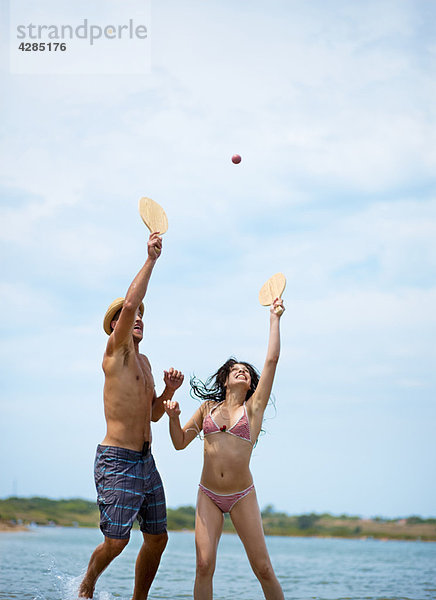 Paar spielt Beachball am Strand