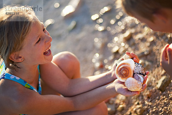 Mädchen finden Muscheln am Strand