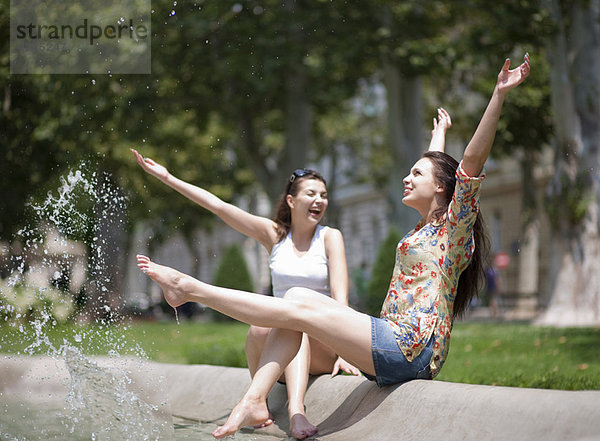 Junge Frauen beim Spritzen in einem Brunnen