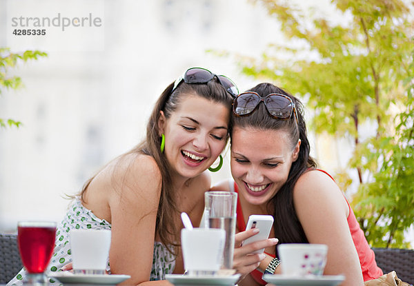 Junge Frauen beim Telefonieren im Café