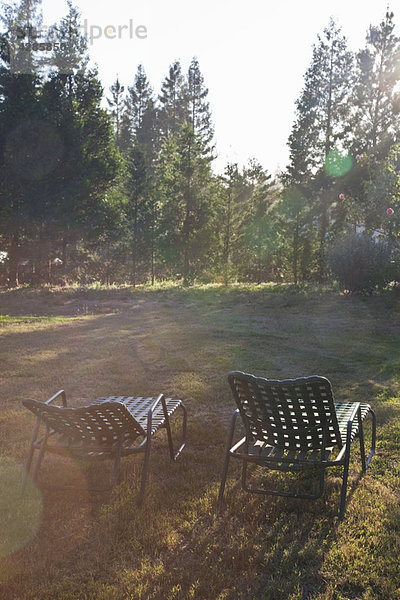 Zwei Liegestühle in der Abenddämmerung im Sommer