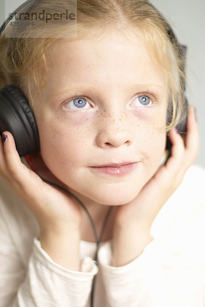 Junges Mädchen mit Kopfhörer aufgesetzt