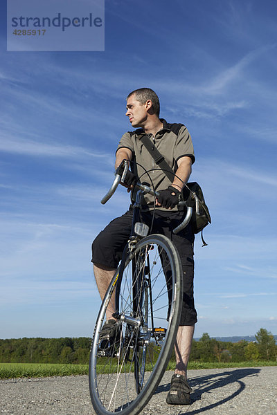 Mann stehend mit Rennrad