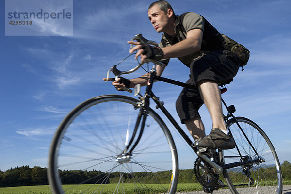 Mann fährt schnell mit dem Rennrad