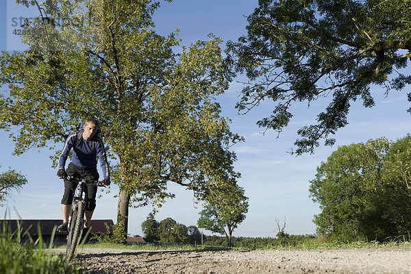 Mann mit Mountainbike unter blauem Himmel