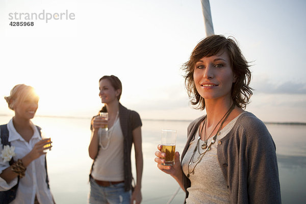 Mädchen trinken Bier auf dem Boot