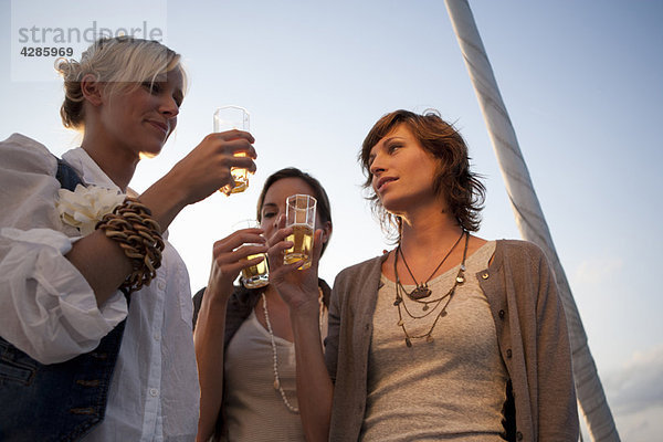 Mädchen trinken Bier auf dem Boot