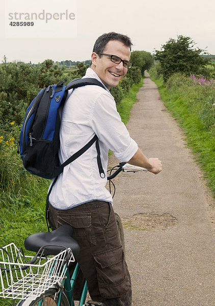 Glücklicher Mann bereitet sich auf das Radfahren im Land vor