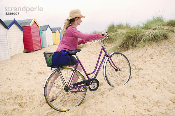 Frauen schieben Fahrrad über den Strand