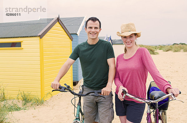 Glückliches Paar am Strand mit Fahrrädern