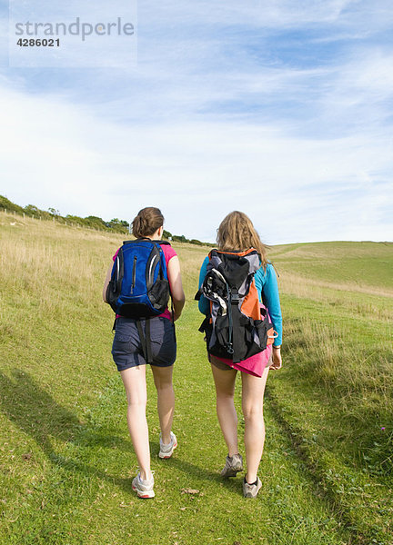 Zwei junge Wandererinnen klettern den Berg hinauf