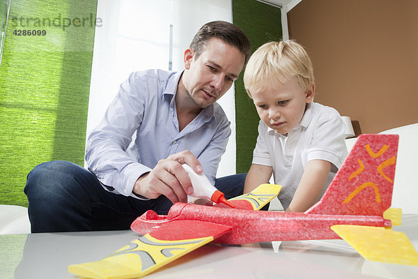 Vater und Sohn reparieren Spielzeugflugzeug