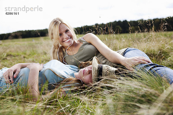 Zwei junge Frauen im Gras liegend