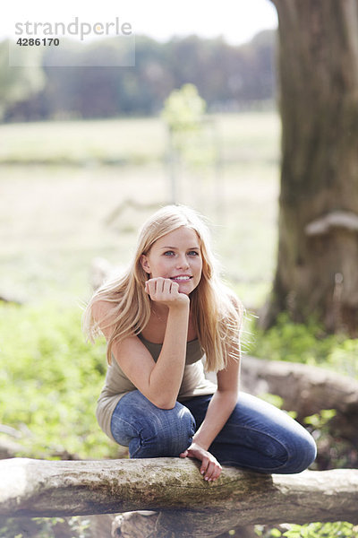 Junge Frau in der Natur sitzend