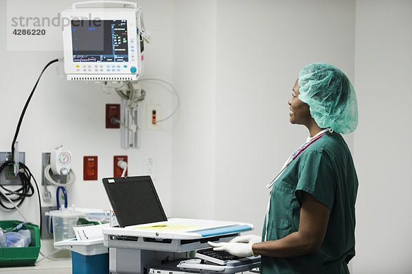Krankenschwester mit computergestützter medizinischer Ausrüstung