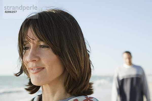 Frau am Strand  wegblickend in Gedanken