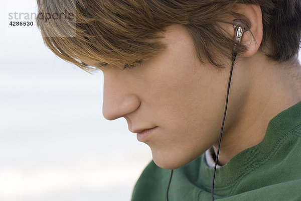 Junge Männer hören Kopfhörer im Freien