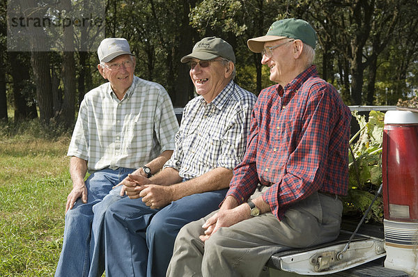 Drei senior Männer sitzen auf der Heckklappe eine Pickup Truck in Manitoba