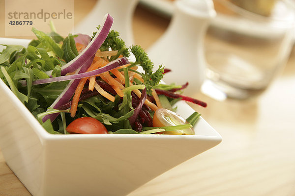 Grünen Salat in quadratischen Schüssel Tisch unscharf festlegen