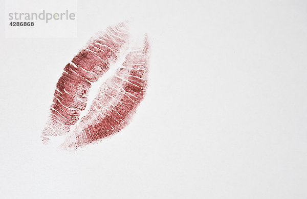 Rote Lippenstift Fleck auf weißem Hintergrund