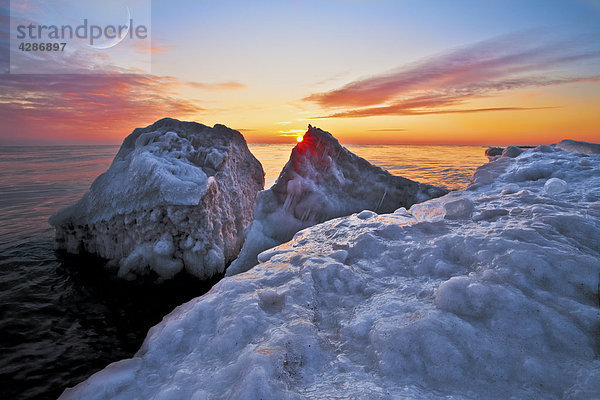 Klumpen des Eises unterbrochen in große Stücke vor der eisigen Küste des Lake Michigan bei Sonnenaufgang  Wisconsin  USA