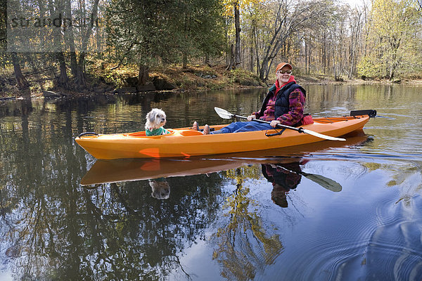 Reife Frau Kajak mit ihrem Hund im Herbst  Moira River  Madoc  Hastings County  Ontario  Kanada