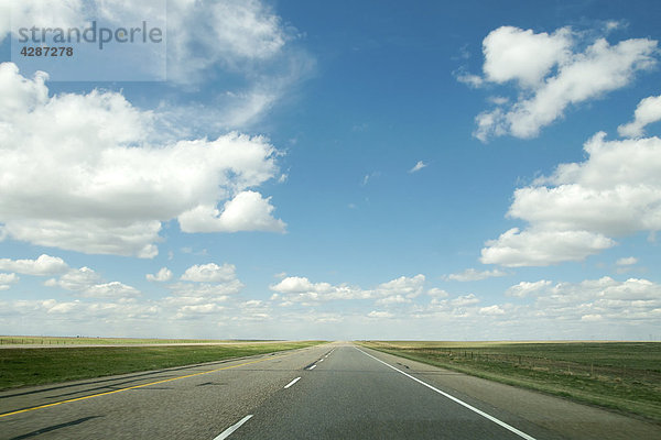 Highway umgeben von endlosen Felder und big blue Skies  Alberta  Kanada