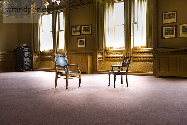 Zwei altmodische Stil Business Stühle in einem großen leere Raum