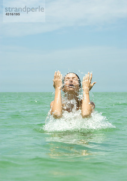 Frau im Meer plätscherndes Gesicht