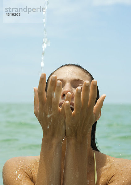 Frau im Meer  Spritzwasser mit den Händen  Nahaufnahme