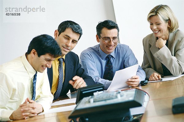 Geschäftskollegen sitzen im Meeting und lächeln