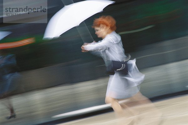 Geschäftsfrau beeilt sich mit Regenschirm