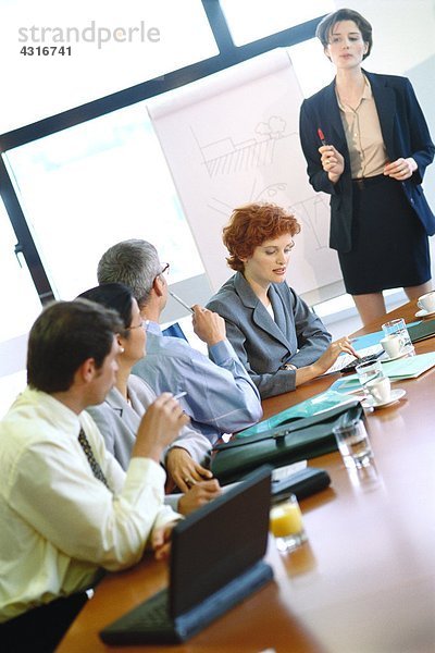 Gruppe von Geschäftsleuten am Konferenztisch während der Präsentation