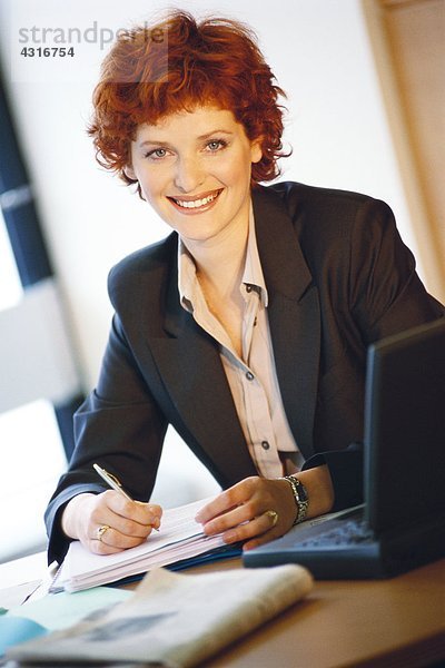 Geschäftsfrau am Schreibtisch sitzend  Portrait